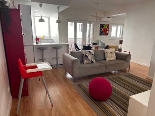 a living room with a couch and a red chair at Cascais Twin Apartments - Daydream PT in Cascais