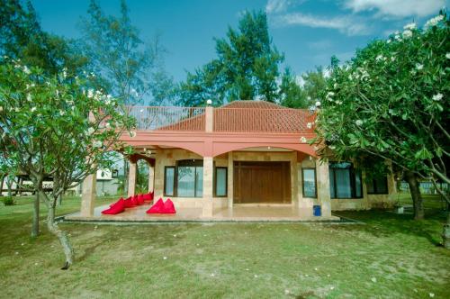 a house with a red roof and red chairs at GILI VIEW By Maza in Teluk Nara
