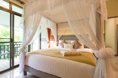 清邁的住宿－Radateeree Boutique Resort，卧室配有带白色窗帘的天蓬床