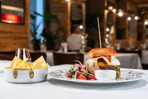 a plate of food with a sandwich and chips on a table at Hotel Piz St. Moritz in St. Moritz
