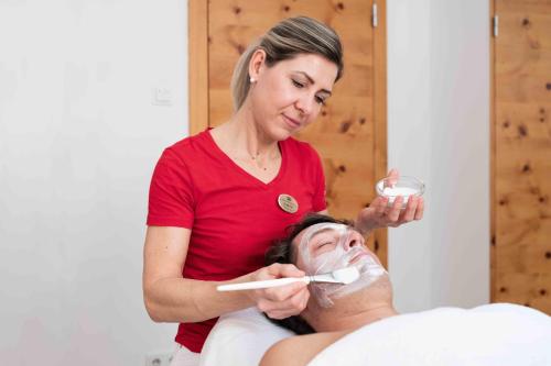 a woman is giving a man a thermometer at SPA Hotel Erzherzog Johann in Bad Aussee
