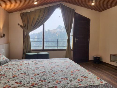 ein Schlafzimmer mit einem Bett und einem großen Fenster in der Unterkunft Cozy Cove - Newly built 3BHK Duplex with rare valley view in Shimla