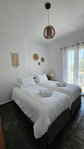 a bedroom with a large white bed with towels on it at Enalia Studio in Korissia