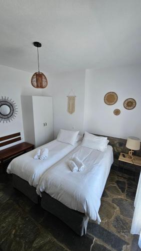 a bedroom with a large white bed with towels on it at Enalia Studio in Korissia