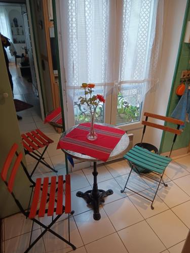 ein Zimmer mit Stühlen und einem Tisch mit einer Vase darauf in der Unterkunft Apart calmo em paris jourdain in Paris