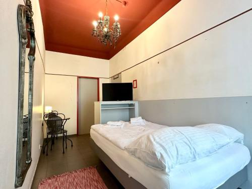 a bedroom with a bed and a tv and a chandelier at Very Central, 5 min to city center, Self Check In in Vienna