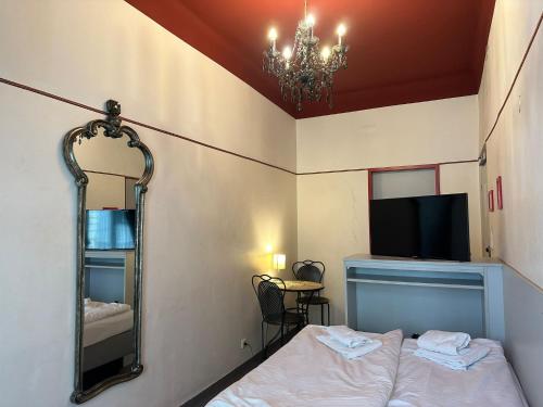a bedroom with a mirror and a bed and a television at Very Central, 5 min to city center, Self Check In in Vienna