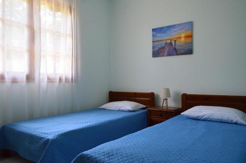 a bedroom with two beds and a window at View of the Castle and the Sea 1 in Platamonas