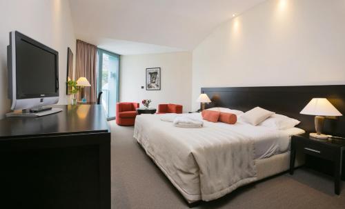 a bedroom with a large bed and a flat screen tv at Admiral Grand Hotel in Slano