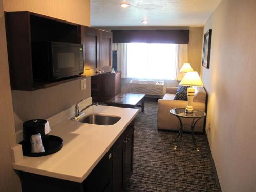 a kitchen with a sink and a living room with a couch at Best Western Timpanogos Inn in Lehi