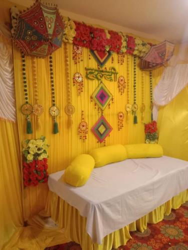 a room with a table with a yellow curtain and flowers at Hotel White Cloud in Banikhet