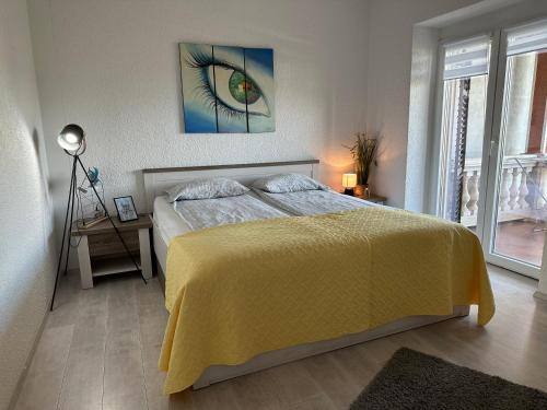 a bedroom with a bed with a yellow bedspread and an eye at Apartment Peloža 1 in Poreč