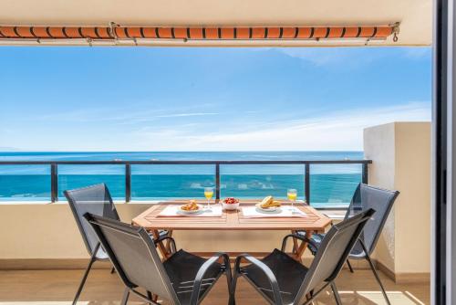 einen Tisch und Stühle mit Meerblick in der Unterkunft BEACHFRONT -- NEW LUXURY Apartment -- 1ª Linea Playa -- Fuengirola CITY CENTER -- Private PARKING -- Panoramic Sea Views -- in Fuengirola