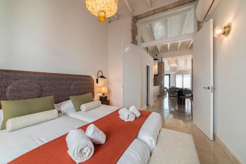 Un dormitorio con dos camas con toallas encima. en Slow Suites Salvador, en Sevilla
