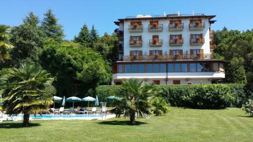 a hotel with a swimming pool and palm trees at Hotel Diana in San Zeno di Montagna