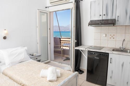 a kitchen with a bed and a view of the ocean at ARTEMIS beach studios in Kalamaki Heraklion