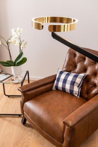 a brown leather couch sitting in a living room with a lamp at Villa Maison Eveline mit Privat Spa - chez Douverne in Sommerach