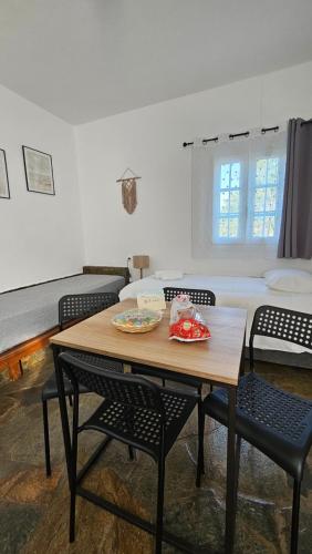 um quarto com uma mesa e cadeiras e uma cama em Enalia Apartments em Korissia