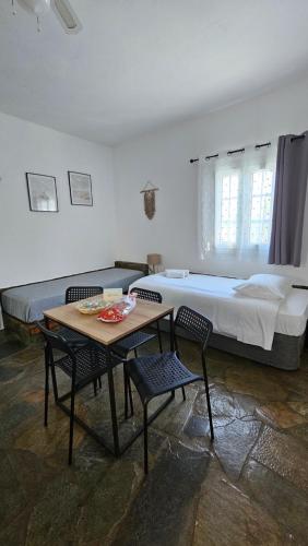 a bedroom with a bed and a table and chairs at Enalia Apartments in Korissia