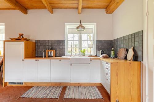 a kitchen with white cabinets and a window at Fredensgaard nær Billund in Jordrup