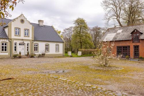 a large white house and a brick building at Fredensgaard nær Billund in Jordrup
