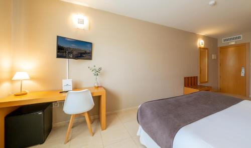 a hotel room with a bed and a desk at La City Estación in Alicante