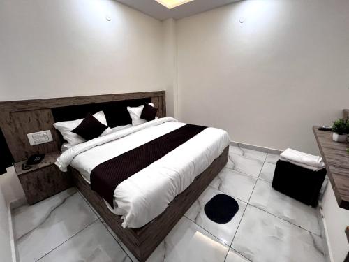 - une chambre dotée d'un grand lit avec des draps noirs et blancs dans l'établissement Dev Palace and Restaurant, à Haridwar