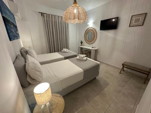 une chambre d'hôtel avec un lit et un lustre dans l'établissement Dedes Apartments, à Skala