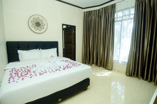 a bedroom with a large bed with flowers on it at GILI VIEW By Kalma in Teluknarat