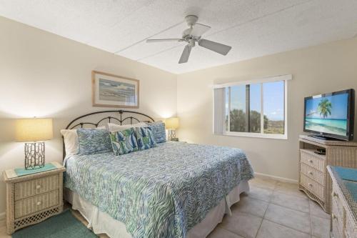 a bedroom with a bed and a flat screen tv at Life's a Beach-Oceanfront condo in Saint Augustine Beach