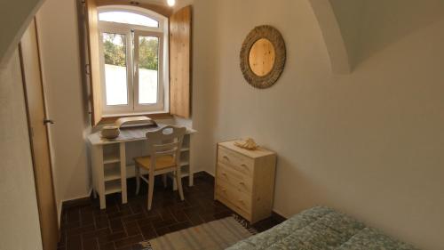 1 dormitorio con escritorio, 1 cama y ventana en WavePortugal Surf & Stay, en Raposeira