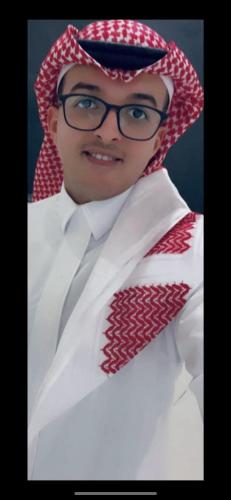 Una mujer con gafas, camisa blanca y corbata roja. en الرياض, en Riad