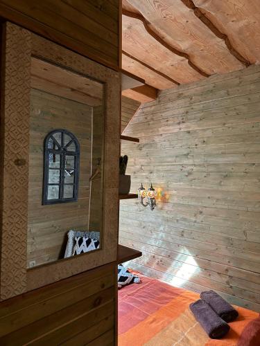 a room with a mirror in a wooden wall at Rakši in Cēsis