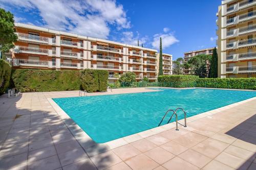 - une piscine en face d'un immeuble dans l'établissement La Lauve - Studio climatisé avec piscine partagée, à Saint-Raphaël