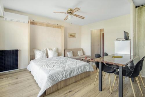 une chambre avec un lit et une table avec des chaises dans l'établissement La Lauve - Studio climatisé avec piscine partagée, à Saint-Raphaël