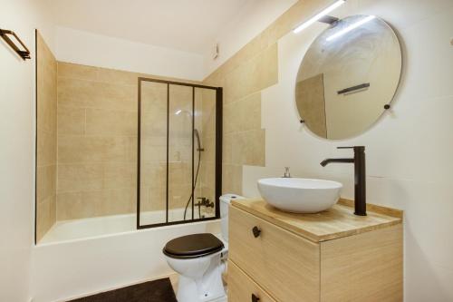 une salle de bain avec un lavabo, des toilettes et une baignoire dans l'établissement La Lauve - Studio climatisé avec piscine partagée, à Saint-Raphaël