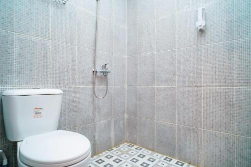 uma casa de banho com um WC e um chuveiro em Mess Rejeki Redpartner em Sampit