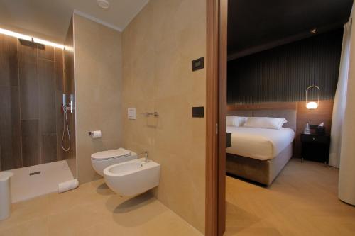 a bathroom with a bed and a toilet and a sink at Hotel Namia by Dori in Bardolino