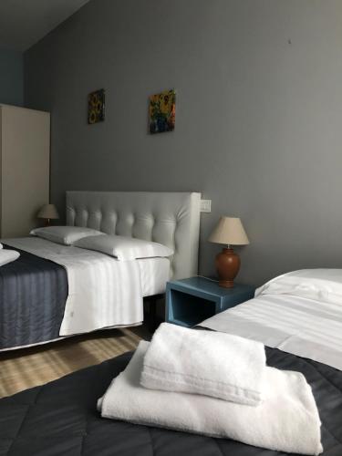a bedroom with two beds with towels on a table at Camere Girasole in Lazise