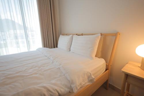 a white bed in a room with a window at The Ocean Villa in Fujairah