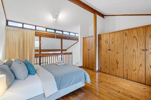 a bedroom with a large bed with wooden paneling at 26 Cottesloe Steps To Beach - Sleeps 2 - SUPERHOG REQUIRED in Perth