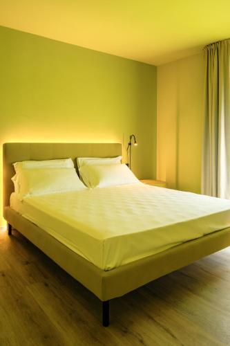 a bedroom with a large bed with white sheets at Camoma Aparthotel - Suites Apartments in Jesolo