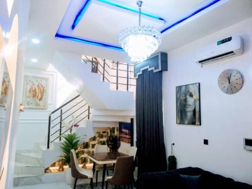 a living room with a table and a clock on the wall at Luxury House In Lekki Lagos in Lagos