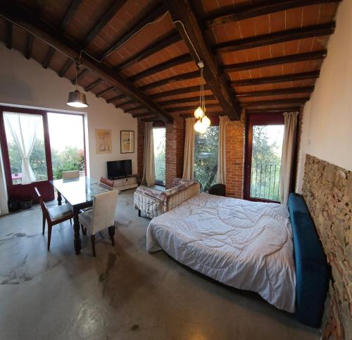 Montemagno的住宿－Casa L Oliveta，一间卧室配有一张大床和一张桌子及椅子