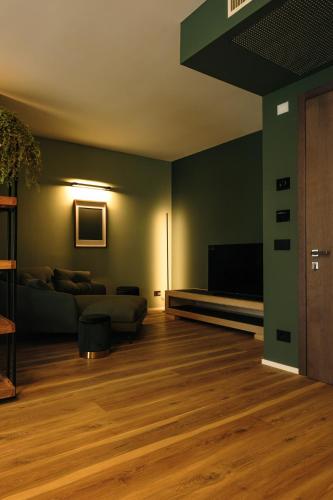 a living room with a couch and a television at Camoma Aparthotel - Suites Apartments in Jesolo