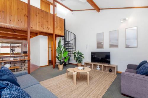 a living room with a couch and a table at 14 Cottesloe - steps from beach - sleeps 2 in Perth