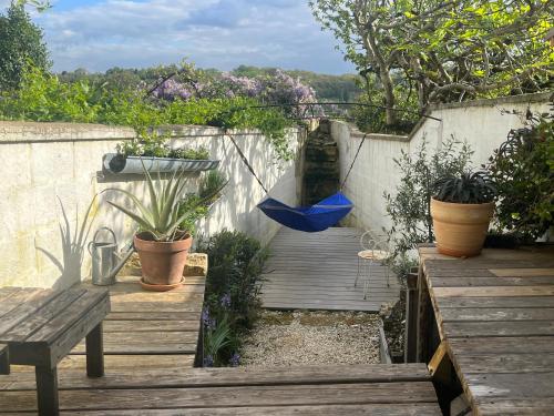 un patio avec une terrasse en bois avec un parasol bleu dans l'établissement Les Jardins suspendus, à Angoulême