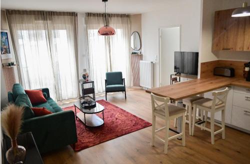 een woonkamer met een groene bank en een tafel bij Appart charmant au cœur de la ville et des commodités in Saint-Ouen