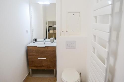 a bathroom with a sink and a toilet and a mirror at Appart charmant au cœur de la ville et des commodités in Saint-Ouen