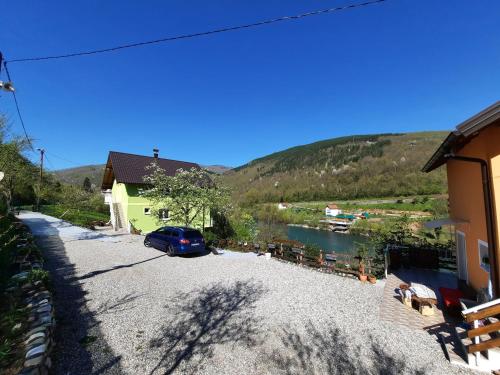 a car parked next to a house and a river at Apartmani Vila na Drini in Foča